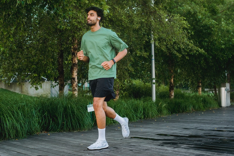 green tee and black shorts sneakers